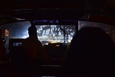 Rear view of silhouette man sitting in car