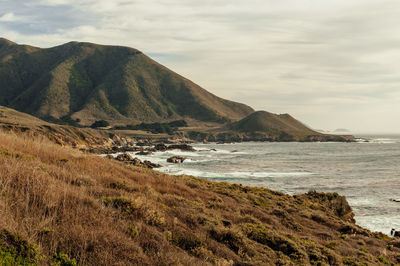 Scenic view of sea and mountains against sky