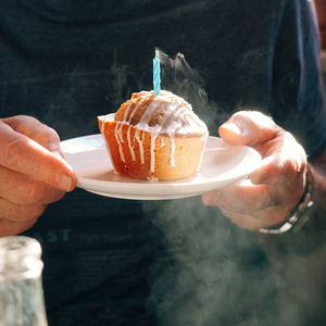 Midsection of man holding cupcake