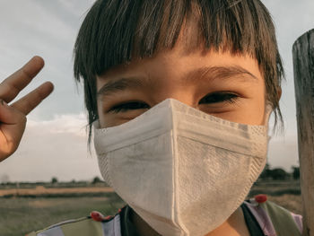 Close-up portrait of boy covering face