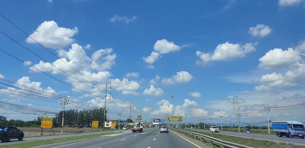 Cars on road against sky in city