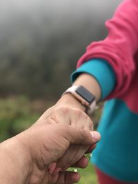 Midsection of couple holding hands