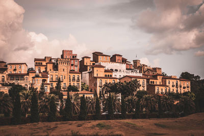 Buildings in city against cloudy sky