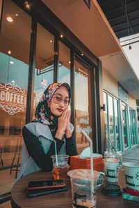 Woman looking away while sitting in restaurant