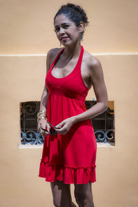 Portrait of a woman wearing red clothes on the street in bright sunny day. salvador, bahia, brazil.