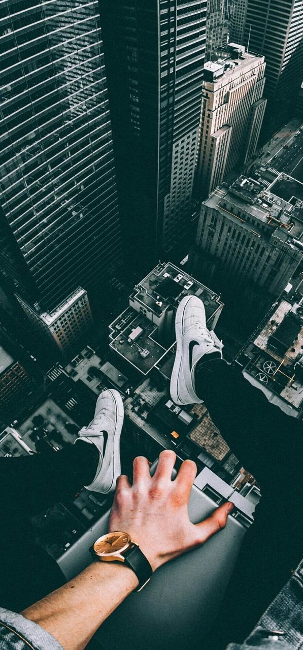 skyscraper, hand, city, architecture, office building exterior, adult, building exterior, built structure, one person, office, personal perspective, high angle view, building, women, cityscape, men, human leg, lifestyles, limb