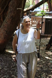 Smiling mature woman on swing in park