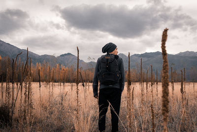 Man standing in the field in front of mountains