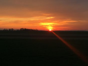 Scenic view of sunset over field