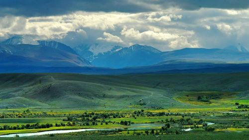 Beautiful view of landscape and mountains against cloudy sky