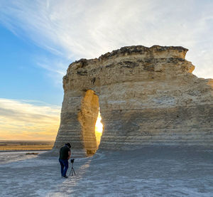 Rear view of woman walking on beach against sky