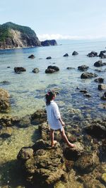 Woman standing on rocks at shore