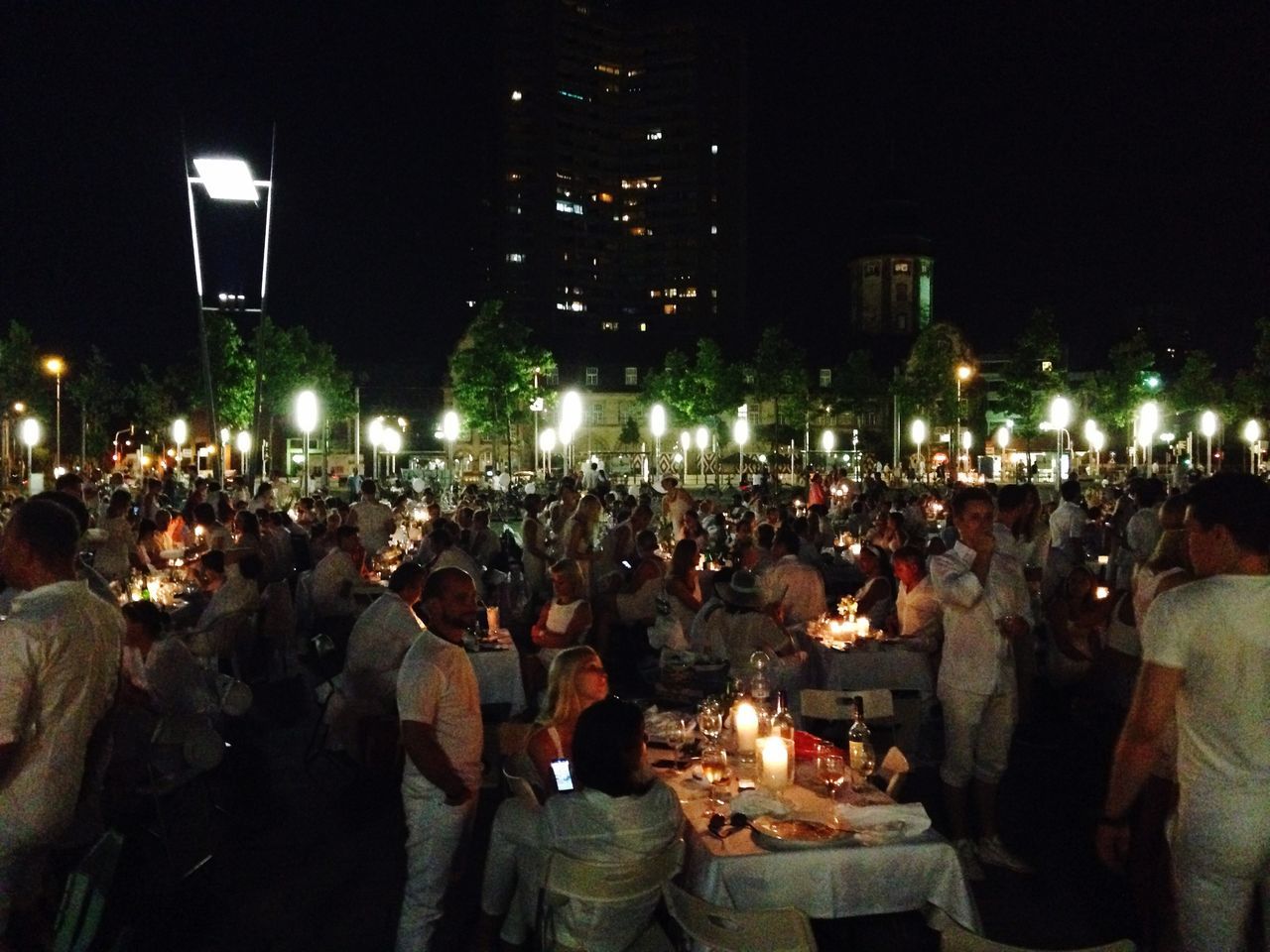 large group of people, night, illuminated, lifestyles, men, crowd, leisure activity, person, togetherness, crowded, building exterior, city, event, architecture, city life, built structure, celebration, standing, enjoyment