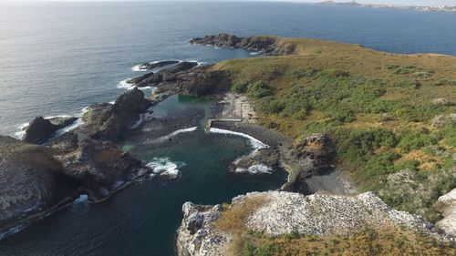 High angle view of sea by cliff against sky