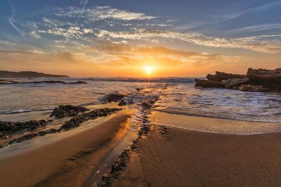 Scenic view of beach against sky during sunset