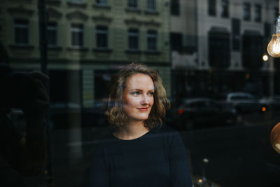 Portrait of blonde woman looking through a window