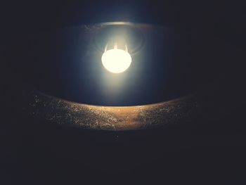 Illuminated lamp against sky at night