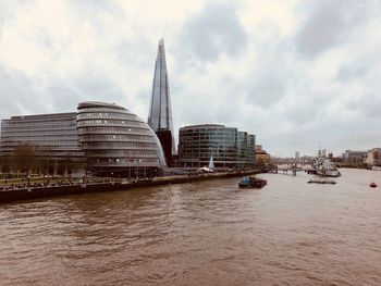 View of buildings in city against cloudy sky