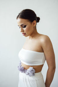 Young woman standing against white background