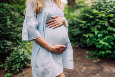 Close up of pregnant belly in nature. pregnant girl in the sunset, pregnant woman relaxing 