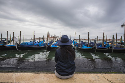 Woman looking at gondolas in the venice lagoon, venice, italy