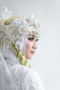 Portrait of woman wearing traditional clothing against white background