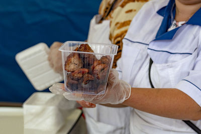 Midsection of man holding kebab pieces