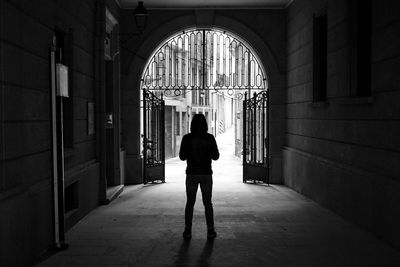 Rear view of man standing in corridor of building