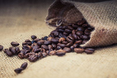 Roasted coffee beans spilling from sack
