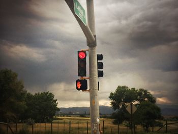 Road sign against cloudy sky