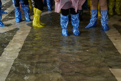 Low section of people standing on wet floor
