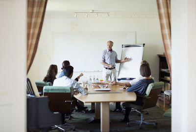 Senior businessman giving presentation in board room