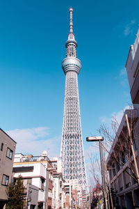 Low angle view of skyscrapers against blue sky