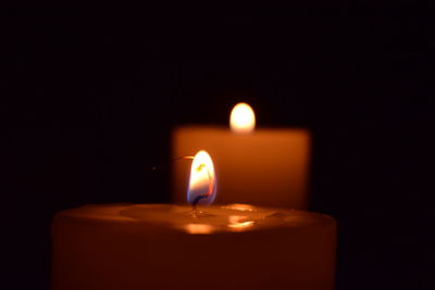Close-up of lit candle in dark room