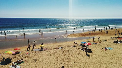 People at beach against sky