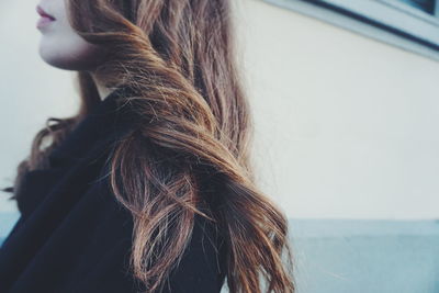 Side view of young woman with long brown hair outdoors