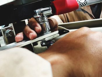 Cropped hand using machinery in workshop