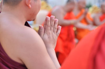 Midsection of monks praying in temple