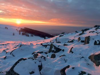 Scenic view of frozen lake against sky during sunset
