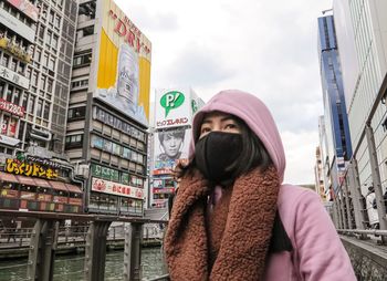 Low angle view of woman with covered face in city