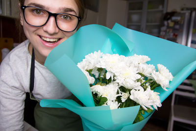 Portrait of young woman holding bouquet