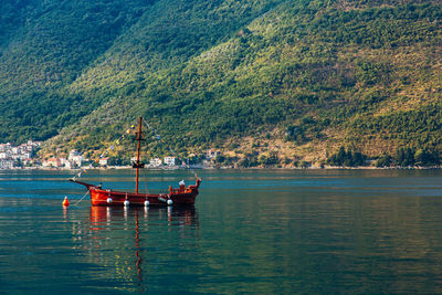 Sailboats in lake against trees