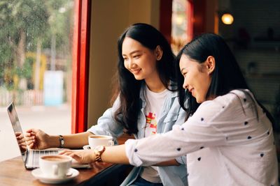 Young woman using mobile phone in cafe