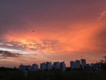 View of city against cloudy sky during sunset