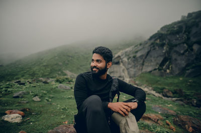 Young man sitting on mountain