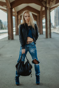 Portrait of smiling young woman standing on road