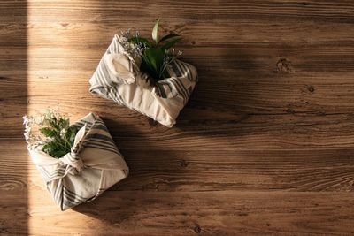 Two pastel-colored furoshiki gifts and craft decor on on wooden background beautiful gift wrapping