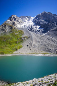 Scenic view of lake and mountains against blue sky