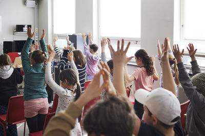 Children raising hands in class