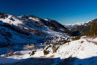 Scenic view of snowcapped mountains against blue sky